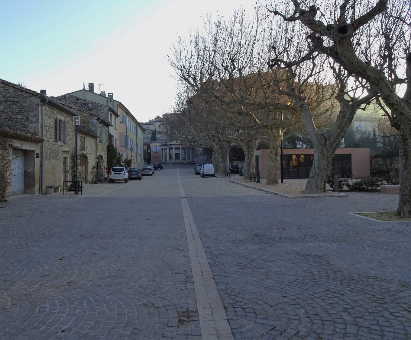 La place du Mail à Grignan, avec le lavoir à colonnes au fond