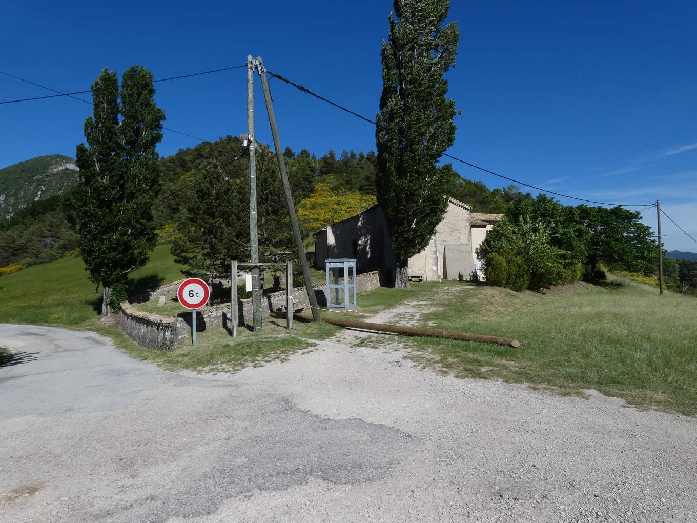 La place du Château à Rochefourchat, avec l'église Saint-Pierre, le mur du cimetière et la cabine téléphonique